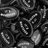 A pile of black rubber coins pouches that have the statement "It's Whatever" on them.